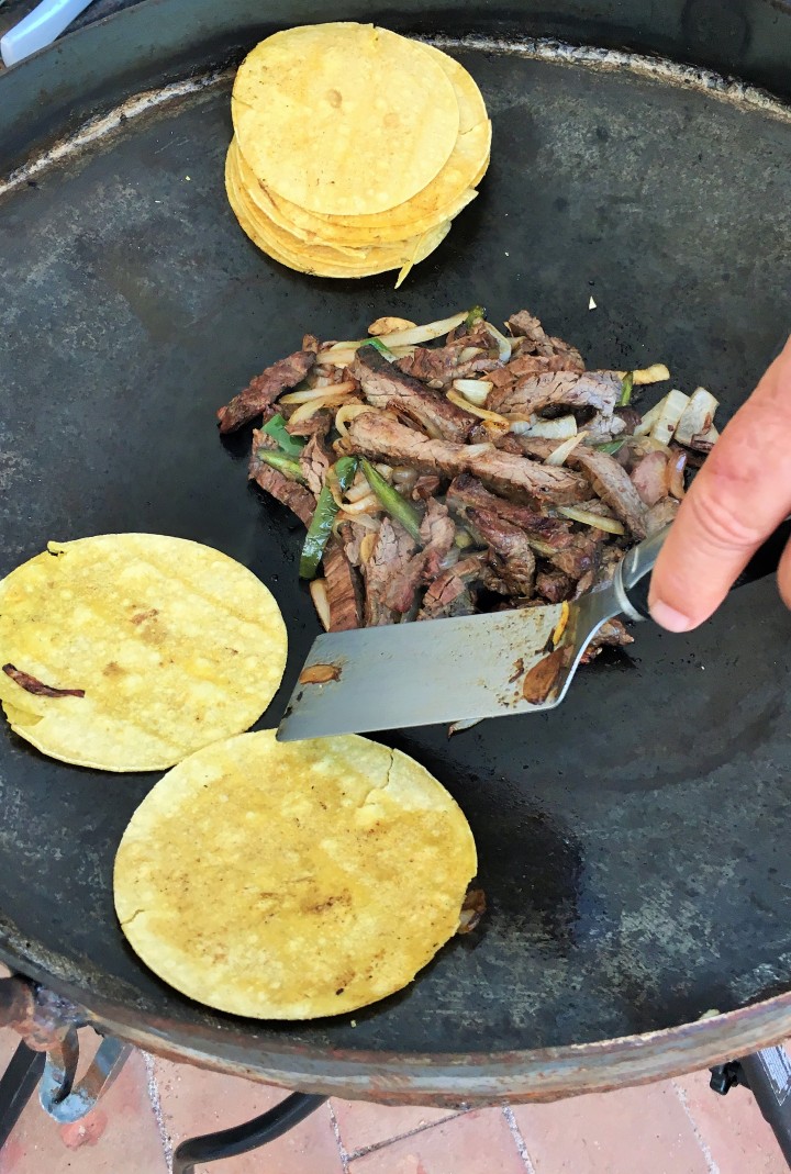 Beef fajitas with onions, peppers and tortillas on the disco.