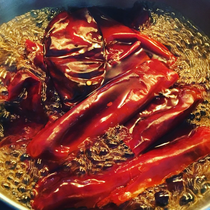 Red chiles boiling from a dried state.