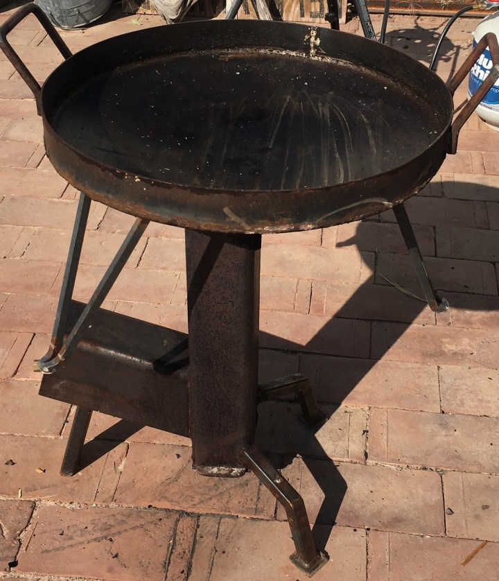 The discada sitting atop the rocket stove.