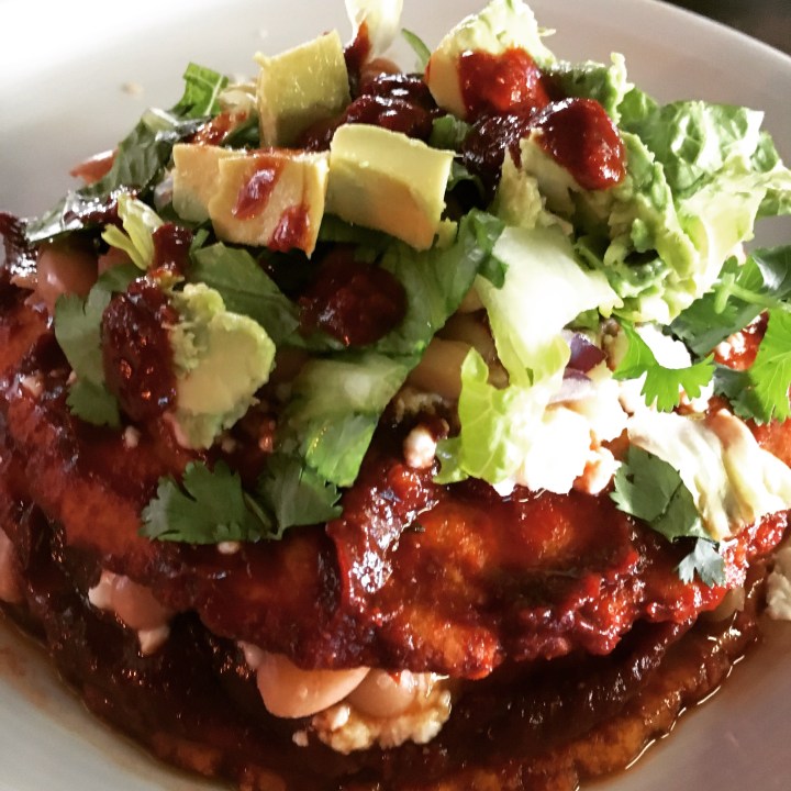 A stack of red with freshly made pintos, homemade red sauce and tortillas, topped with the goods. This meal took much longer to prepare than to eat!